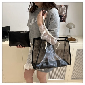 Detail of transparent PVC tote bag with white rope handles and inner leather pouch