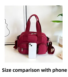 Size comparison of a burgundy canvas handbag with a smartphone showing multi-pocket detail