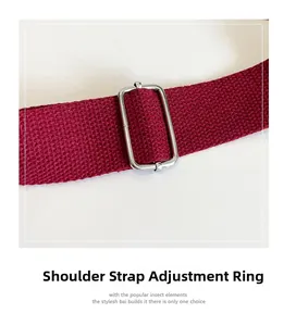 Detail of adjustable silver metal buckle on a burgundy woven texture shoulder strap