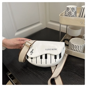 Gros plan du motif piano rétro et du texte I LOVE MUSIC sur un sac bandoulière blanc