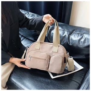 Detail of versatile beige nylon Boston bag showing functional pockets and woven handles