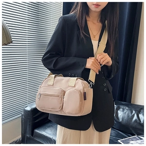 Detailed view of khaki nylon multi-pocket crossbody bag with adjustable wide shoulder strap