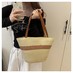 Detail der gewebten Strohtasche mit Ethno-Gurt und braunen Kunstledergriffen