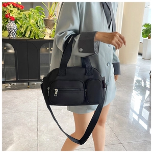 Close-up of black nylon Boston bag with multiple front pockets and adjustable shoulder strap