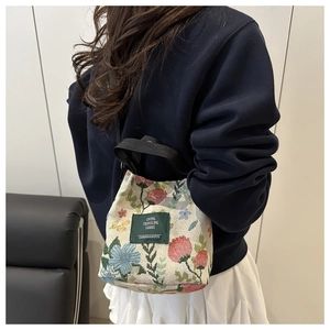Detail of vintage floral jacquard bucket bag with woven handles and brand label