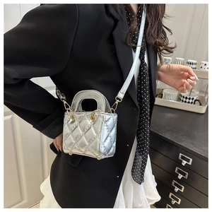 Silver quilted small square bag with metallic texture and crossbody chain strap on model
