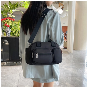 Detail of a black nylon Boston bag with functional multi-pocket and wide shoulder strap