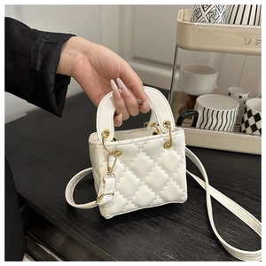 Close-up of white quilted mini handbag featuring gold hardware and elegant embroidery