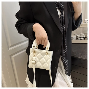 Détail du mini sac blanc matelassé avec poignée anneau doré et bandoulière réglable