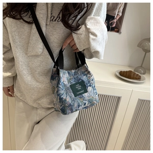 Detail of teal jacquard floral tote bag with adjustable strap and logo patch