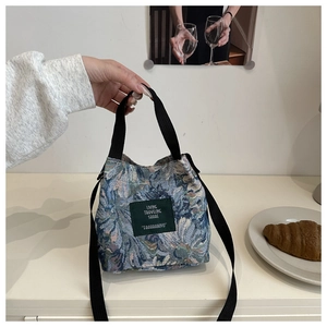Detail of floral jacquard crossbody bag showing high-quality fabric texture and tag