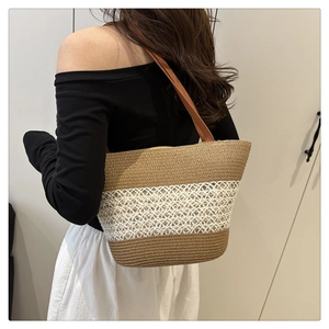 Detail of woven straw tote bag featuring brown and white stripes with crochet mesh texture