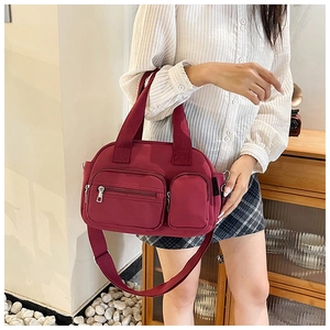 Detail of wine red nylon boston bag with multiple pockets and adjustable shoulder strap