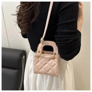 Detailed close-up of light pink mini crossbody bag with classic quilted diamond pattern