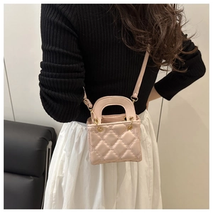 Close-up of a pink quilted mini crossbody bag worn with a white pleated skirt and black top