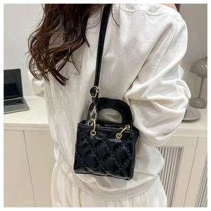 Detailed view of black quilted patent leather bag showing gold hardware and rivets
