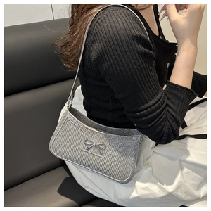 Detailansicht der silbernen Glitzer-Schultertasche mit Metallschleife und Strass