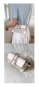 Detail of minimalist beige baguette bag with leather stitching and woven texture