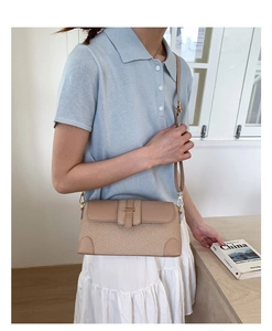 Close-up of retro baguette bag with straw patchwork and faux leather detail