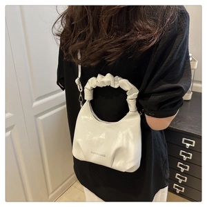 Detailed view of white pleated dumpling bag with fashion letter print and sleek handle