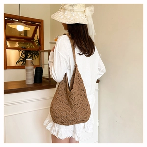 Sac hobo en tricot marron avec motif losanges présenté dans un cadre décontracté
