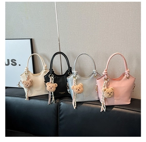 Detailed view of bucket bags in cream black silver and pink with cute bear charms