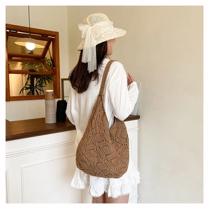 Brown crochet hobo bag with hollow diamond pattern and straw sun hat with bow detail