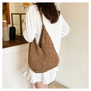 Modèle portant un sac hobo marron tricoté à la main avec motif de losanges ajourés