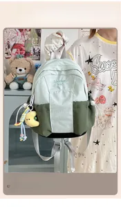 Close-up of color-block backpack with mint and olive nylon panels and cloud pendant