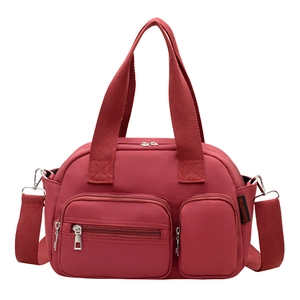 Deep red multi-pocket nylon pillow bag with silver zippers and adjustable shoulder strap