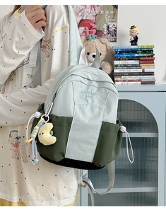 Detail of color-block nylon backpack with moon plush charm and bead strap accessories