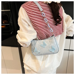 Detail of light blue tote bag with delicate lace patterns and 3D butterfly appliqués