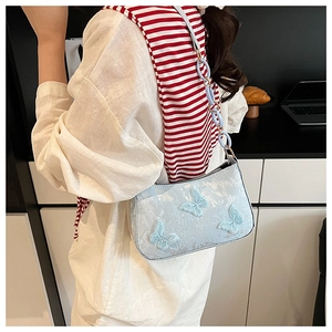 Detail of light blue jacquard tote with 3D butterfly appliqués and chain strap