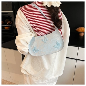 Dettaglio borsa sottobraccio azzurra con farfalle 3D e tessuto jacquard raffinato