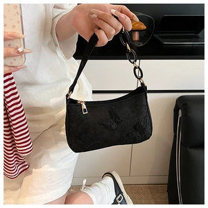 Detail of black fabric tote bag with 3D butterfly embroidery and metal chain strap