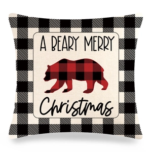 Close-up of linen Christmas pillow case with bear silhouette and buffalo plaid border