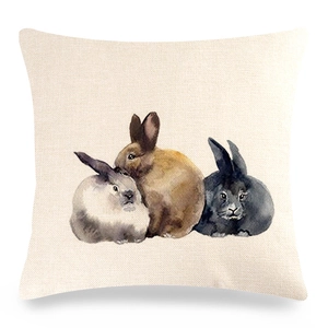 Detail of linen pillowcase featuring three watercolor Easter bunnies on beige fabric