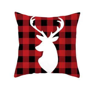 Detail of red and black buffalo plaid Christmas pillow cover with white reindeer silhouette