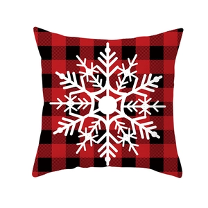Detail of red and black buffalo plaid Christmas pillow case with white snowflake print