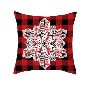 Detail of red and black buffalo plaid Christmas pillow case with white snowflake motif