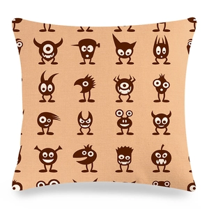 Detail of linen cushion featuring brown cartoon monster patterns on beige fabric