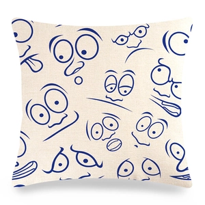 Detailed view of linen cushion cover showing navy blue cartoon face patterns and texture