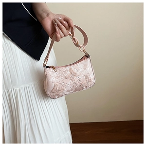 Close-up of elegant 3D butterfly embossing and gold chain on pink tote bag