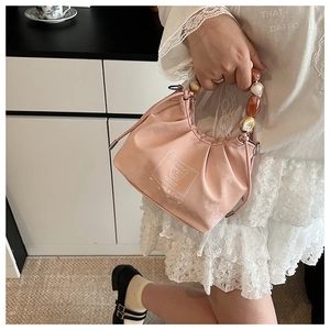 Detailed view of pink drawstring cloud bag featuring premium beaded handle and bear logo