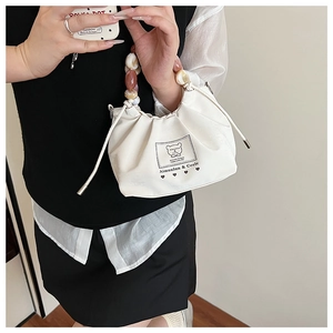 Detail of white pleated handbag with colorful beaded handle and brand logo display