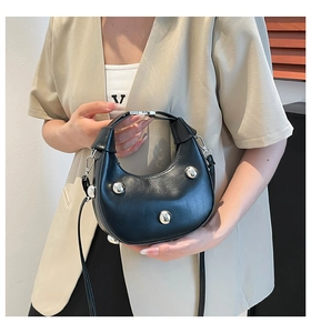 Detailansicht der schwarzen Leder-Hobo-Tasche mit drei Silbernieten und Metallbeschlägen