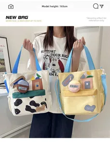 Detail of canvas tote bags with cute house embroidery and blue straps on a model