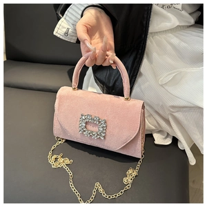 Detail of pink faux suede handbag featuring a square crystal buckle and gold chain strap