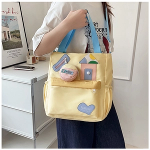 Detail of yellow canvas tote bag with blue strap and creative house-shaped patchwork design