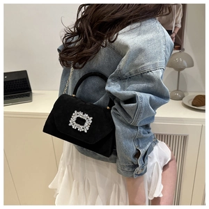 Sac à main chic en velours noir avec boucle en cristal et chaîne dorée sur un mannequin